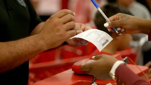 క్రెడిట్ కార్డు బిల్లుపై సంతకం చేస్తున్న వ్యక్తి