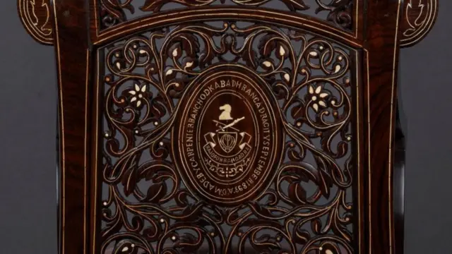 या खुर्चीचे सर्वात मोठे आकर्षण म्हणजे तिच्या मागील बाजूला असलेली नावाची पाटी (Plaque). या पाटीवर ही खुर्ची तयार करणाऱ्या कारागिराचे नाव आणि ती कोणत्या महिन्यात व कोणत्या वर्षी बनवली, याची स्पष्ट नोंद आहे.