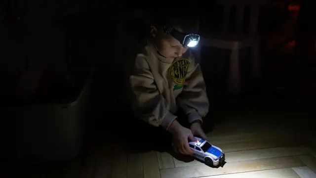 Хлопчик грає з ліхтариком на голові 