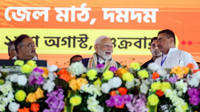 कोलकाता में एक कार्यक्रम के दौरान पश्चिम बंगाल विधानसभा में विपक्ष के नेता सुवेंदु अधिकारी और पश्चिम बंगाल में बीजेपी के प्रदेश अध्यक्ष सामिक भट्टाचार्य के साथ मंच पर मौजूद प्रधानमंत्री नरेंद्र मोदी