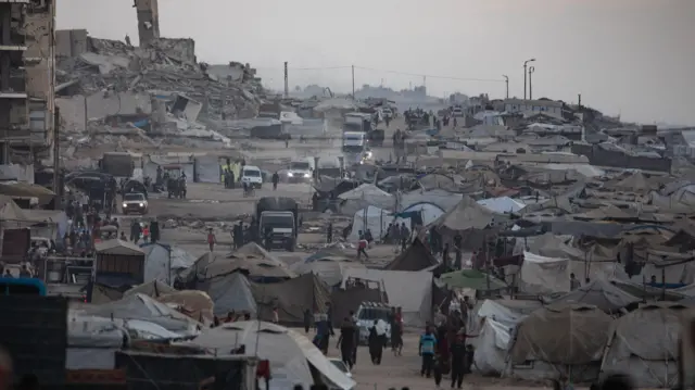 نازحون فلسطينيون من شمال قطاع غزة يفرون مع أمتعتهم إلى مخيم للنازحين على طول شارع الرشيد غرب مدينة غزة