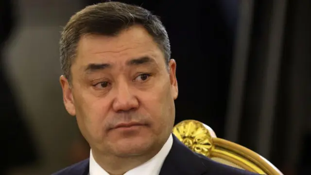 Лицо президента Кыргызстана Садыра Жапарова крупным планом, он в официальном костюме, сидит на стуле с позолотой