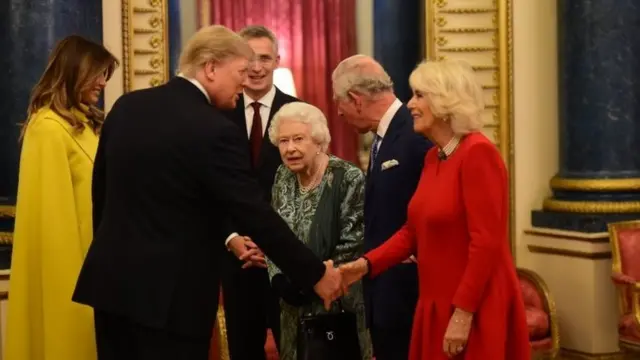 Queen Elizabeth II talks to US President Donald Trump and wife Melania as she hosts a reception for NATO leaders