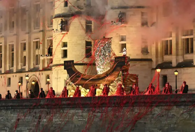 Figuras sin cabeza que representan a la reina María Antonieta del siglo XVIII actúan a lo largo de un dique del río Sena, frente a la Conciergerie, donde la reina estuvo cautiva durante la Revolución Francesa, en la ceremonia de apertura de los Juegos Olímpicos de París 2024