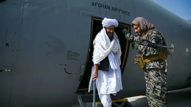Seorang anggota Taliban turun dari pesawat militer Afghanistan pada 31 Agustus lalu.