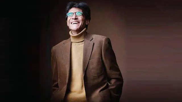 عکسی از ناصر تقوایی، کارگردان سینما، که بر پس‌زمینه‌ای رنگی دیده می‌شود