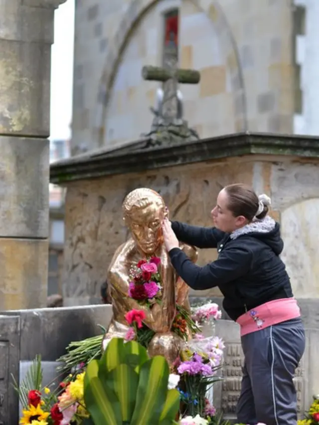 Mujer acaricia estatua de Leo Kopp.