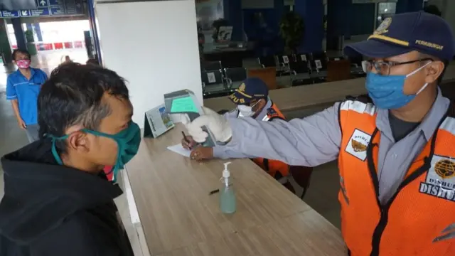 Penumpang bus di Solo Balapan diperiksa suhu oleh petugas.