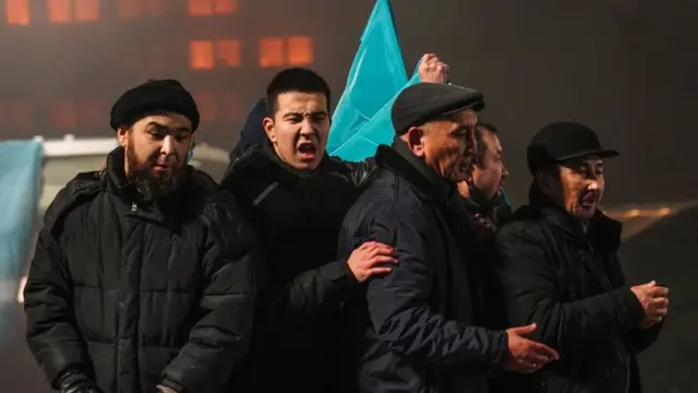 আলমাটিতে সরকারের বিরুদ্ধে বক্তৃতা দিচ্ছেন ক'জন বিক্ষোভকারী।