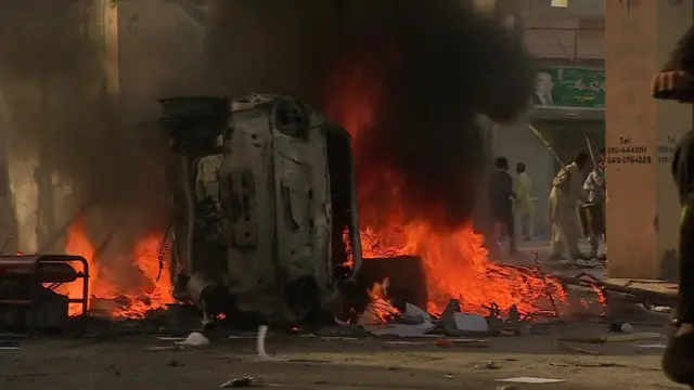 Un vehículo en llamas en una protesta en Kasur, Pakistán.