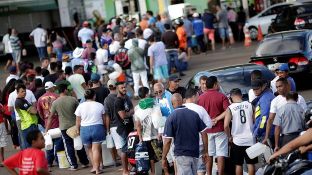 Pessoas e carros fazem fila para comprar combustível em um posto em Luziania (GO), no sétimo dia da greve dos caminhoneiros