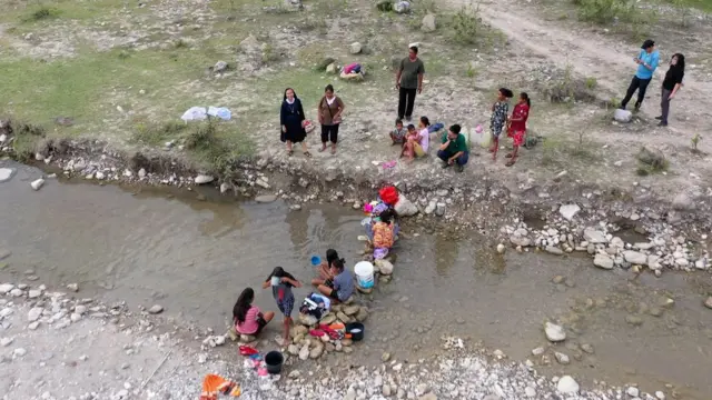 Warga desa harus berjalan jauh untuk mengambil air bersih.