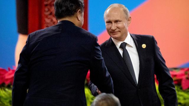 普京在"一带一路"峰会开幕仪式期间跟习近平握手。
