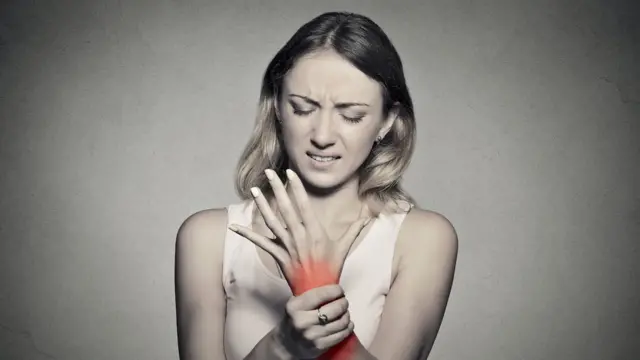 Mujer sintiendo dolor en una mano.