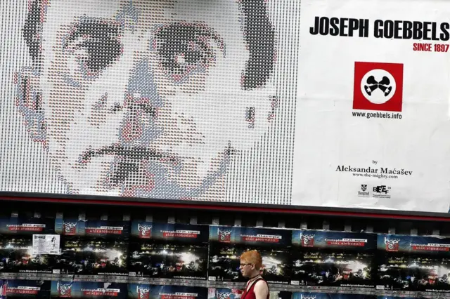 Una mujer pasa frente a una instalación creada sobre Joseph Goebbels creada por la artista serbia Aleksandar Macassev para el festival de verano de Belgrado de 2005.