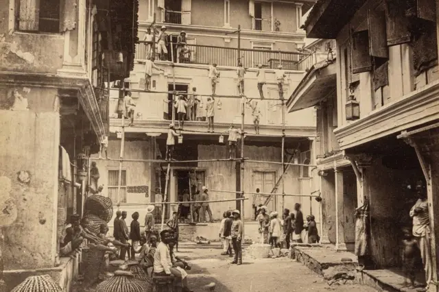 బాంబేలో ప్లేగ్ వ్యాధి సోకిన ఇంటికి సున్నం వేస్తున్న కార్మికులు