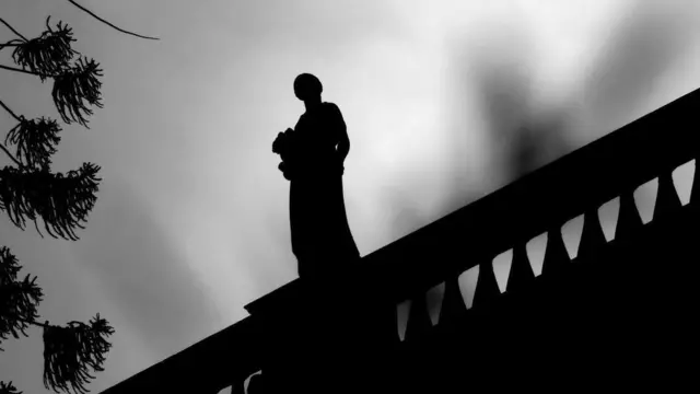 Una estatua en la parte alta de un edificio