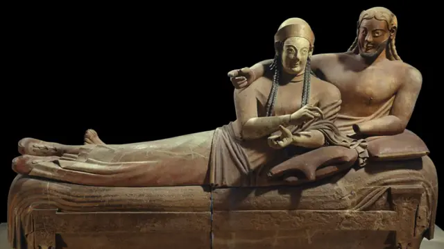 Escultura antiga mostra homem e mulher deitados