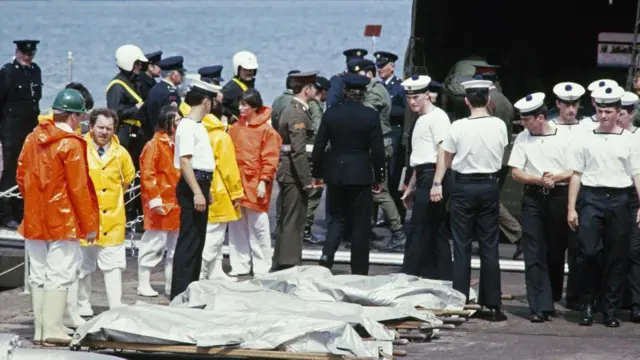 हादसे के बाद राहतकर्मी लाशों को समंदर से निकालकर बाहर लाते हुए