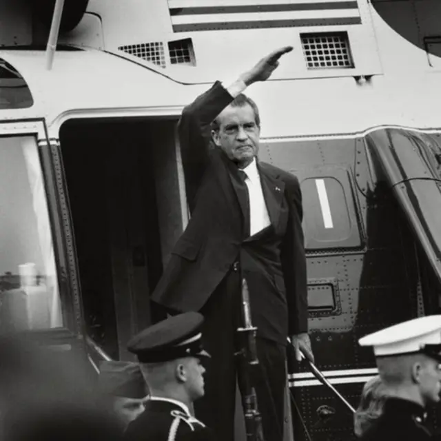 Nixon saludando desde la puerta de un avión.