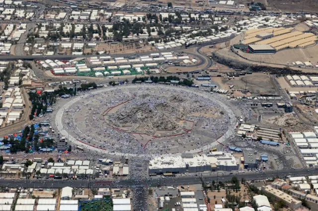 لقطة علوية تظهر جبل عرفات المعروف أيضاً باسم جبل الرحمة، محاطاً بالخيام التي يستخدمها الحجاج، صبيحة يوم عرفة في 15 يونيو/حزيران 2024.