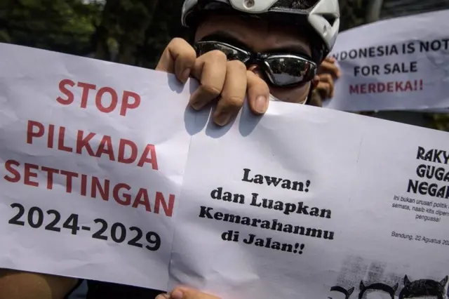 Pengunjuk rasa yang tergabung dalam aliansi mahasiswa dan masyarakat memegang poster saat berunjuk rasa di depan Gedung DPRD Jawa Barat, Bandung, Jawa Barat, Kamis (22/8/24).