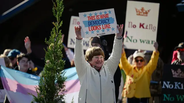 Uma mulher segura um cartaz com a frase “é assim que a democracia se parece” durante um protesto no Kentucky
