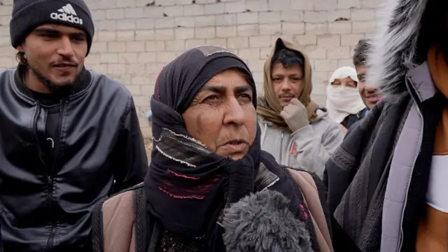 صورة لسيدة تتحدث في المياكروفون وحولها عدد من الشباب