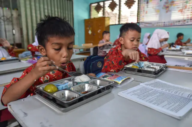 Siswa menyantap makanan saat percobaan pelaksanaan program Makan Bergizi Gratis (MBG) dari Satuan Pelayanan Pemenuhan Gizi (SPPG) Polda Jambi di SDN 006 Kota Jambi, Jambi, Kamis (17/7/2025)