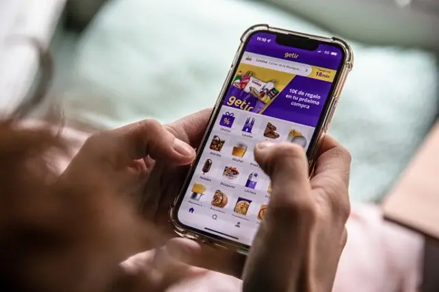Geti uygulamasından sipariş veren el telefonu tutuyor.<p>