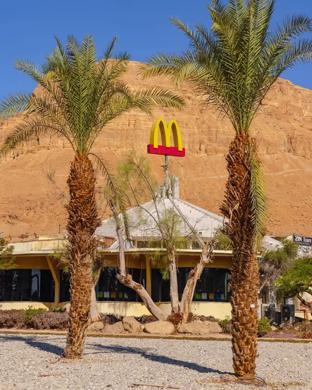 Макдональдс у пустелі, перед ним пальми
