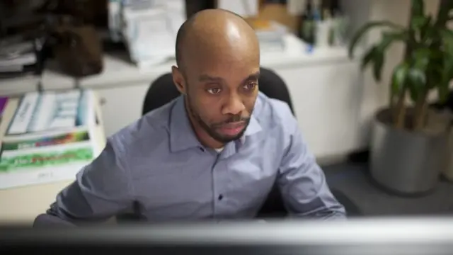 Yusef Ramelize, un graphiste de 34 ans travaillant pour Informa, Inc. travaille sur l'un de ses projets de conception dans son bureau, le 9 décembre 2011 à New York.