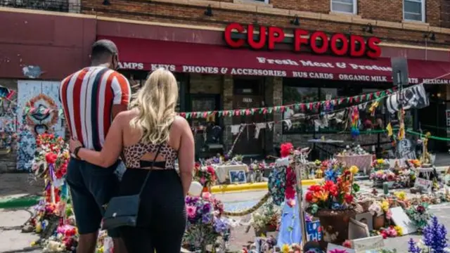 Dos personas frente al establecimiento Cup Foods, donde murió George Floyd.