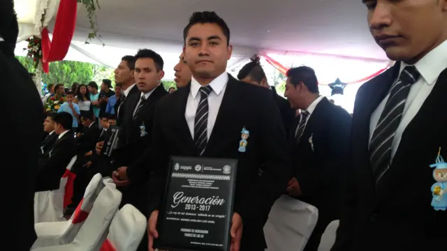 Luis Uriel sostiene un diploma. 