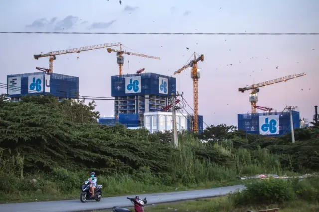 Một người lái xe máy chạy ngang qua một công trường xây dựng ở Thủ Thiêm, TP HCM (ảnh chụp ngày 11/9/2019)