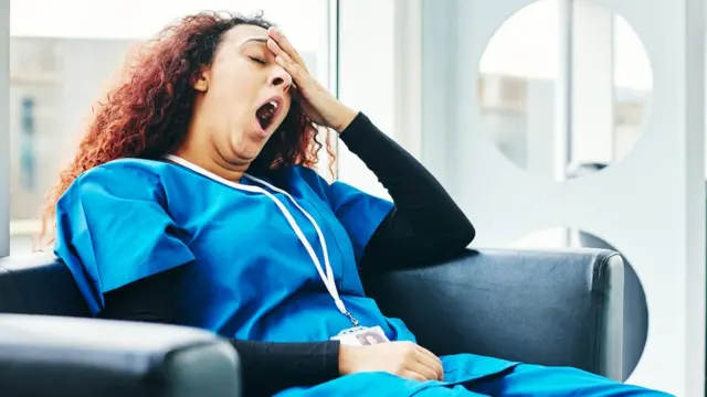 Una mujer enfermera bosteza.