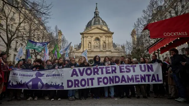 Mulheres reunidas para manifestação segurando faixabetnacional código promocionalapoio à mudança constitucional