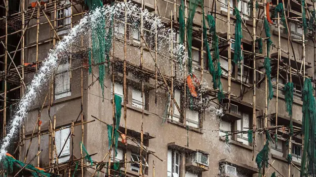 2025年11月27日星期四,消防员正在扑灭香港大埔区宏福苑一栋仍在冒烟的住宅大楼。