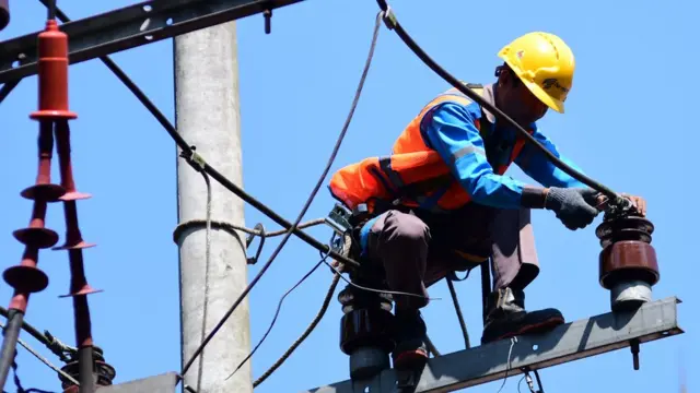 Pekerja melakukan pembenahan jaringan listrik di kawasan perkantoran di depan Balai Kota Malang, Jawa Timur, Rabu (22/06)