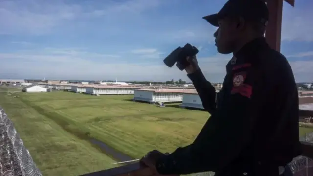 Un garde pénitencier avec des jumelles.