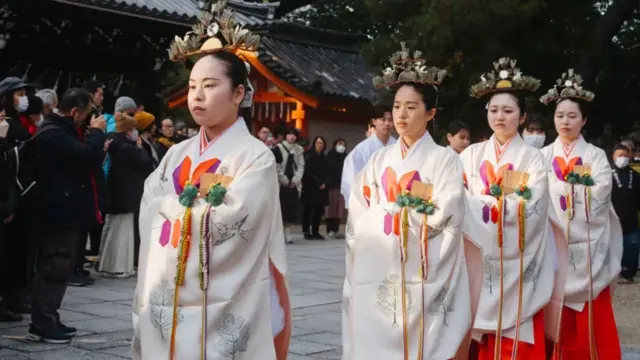Japonya'nın Osaka şehrinde, geleneksel kimono giymiş genç kadınlar, Japonya'nın en eski Şinto tapınaklarından biri olan Sumiyoshi Taisha'da yılın sonunu kutlamak için düzenlenen Şinto ritüel alayında yer alıyorlar.