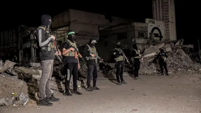 Боевики ХАМАС с автоматами у куч мусора