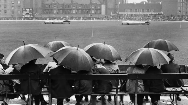 ওভাল ১৯৪৬, বৃষ্টিতে পন্ড ক্রিকেট ম্যাচ দেখতে আসা দর্শকরা ছাতার নিচে