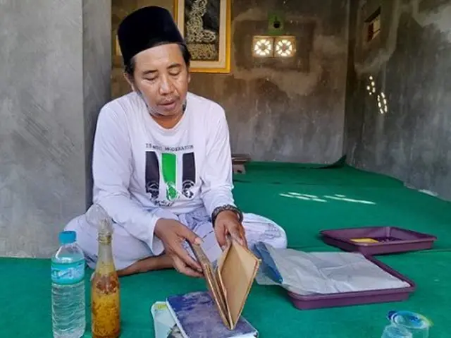 Akhmad Fakih atau Kanjeng Lora menunjukkan kitab, jimat, dan minyak yang digunakan untuk 'membantu klien-kliennya'.