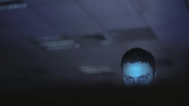 Hombre mirando a la pantalla de una computadora.