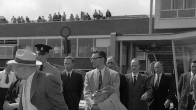 Fuchs oo ay askar geeyeen garoonka diyaaradaha Heathrow, 1959-kii, isagoo u socday Jarmalka Bari, kaddib markii lasii daayay