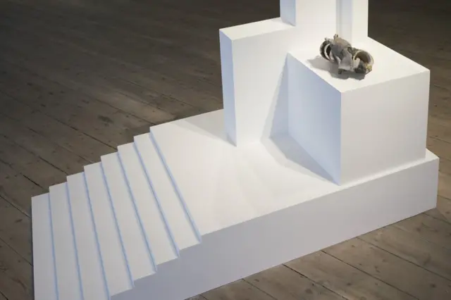 Білий макет монумента "доповнений" рештками розплавленої чашки, зібраними художником зі згорілого будинку на Донбасі