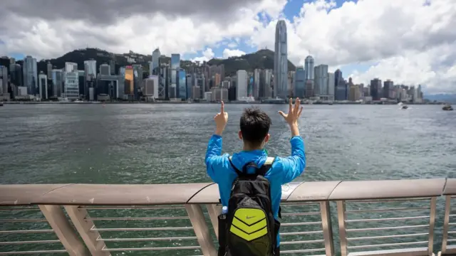 香港九龍尖沙咀海旁一名示威者獨自舉起「五大訴求缺一不可」手勢(17/6/2020)