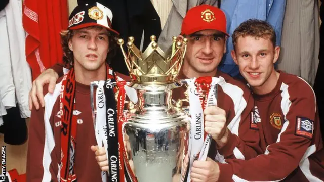 Jordi Cruyff, Eric Cantona and Nicky Butt of Manchester United celebrate in the dressing room with the Premier League trophy in 1997