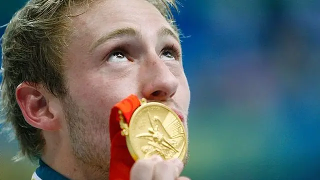 Matthew Mitcham kisses his Olympic gold medal after winning the men's 10m platform diving competition at Beijing 2008